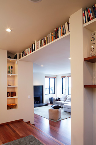 Near-ceiling built-in bookshelves with accent lighting.